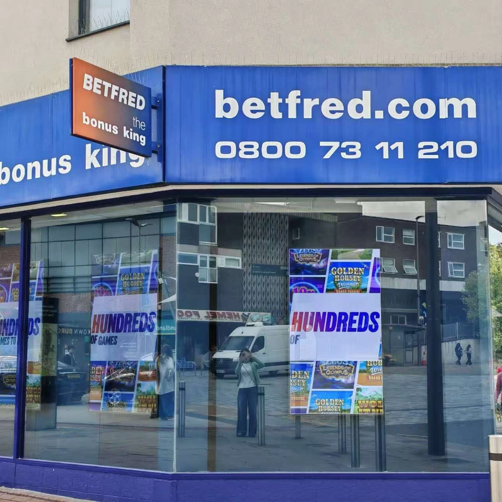 High-brightness LCD window displays visible through a Betfred storefront